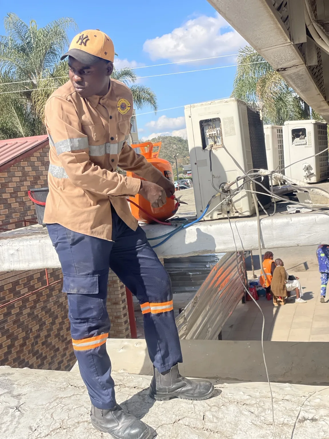 Technician carrying out rooftop air-conditioning service work at Empower Bank Mutare