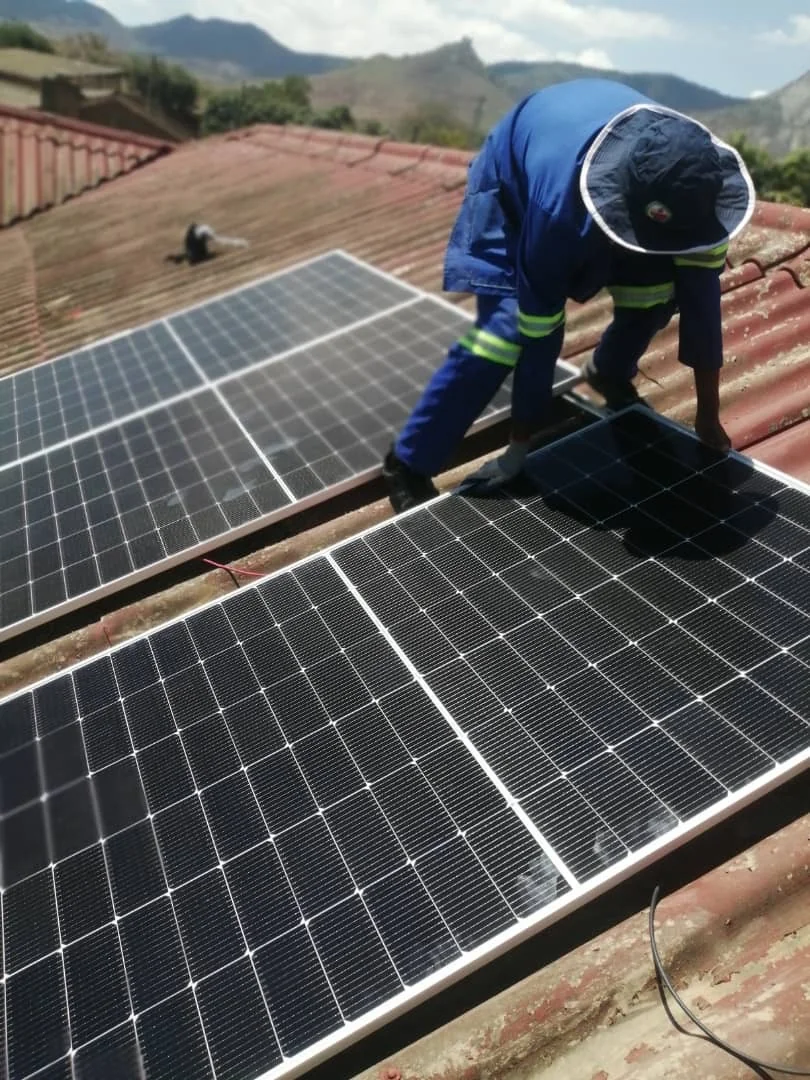 Technician installing rooftop solar panels